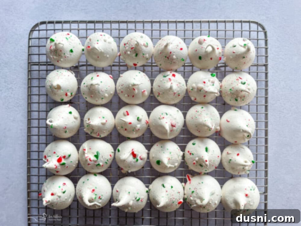 Baked peppermint meringues cooling on a wire rack, perfectly crisp.