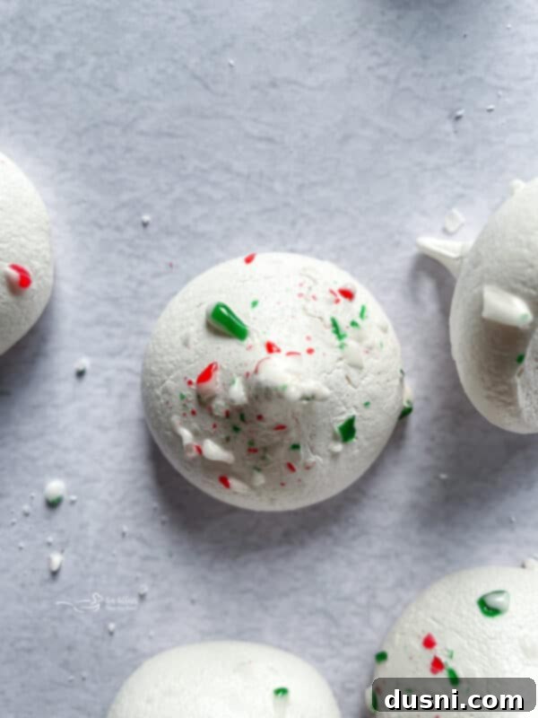 A collection of finished peppermint meringues on a serving platter.