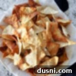 Crispy Air Fryer Wonton Chips 11 Air fryer wonton chips in a napkin lined bowl.