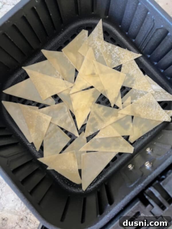 Crispy Air Fryer Wonton Chips 5 Air fryer basket filled with wonton wrappers, ready for cooking.