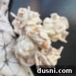 White Ting a lings stacked on a dark surface, highlighting their crunchy texture and white coating.