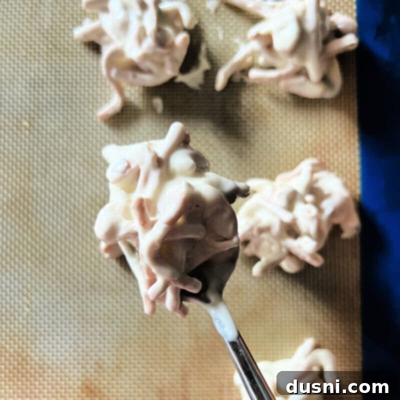 Melted white candy coating in a saucepan, being stirred until smooth.