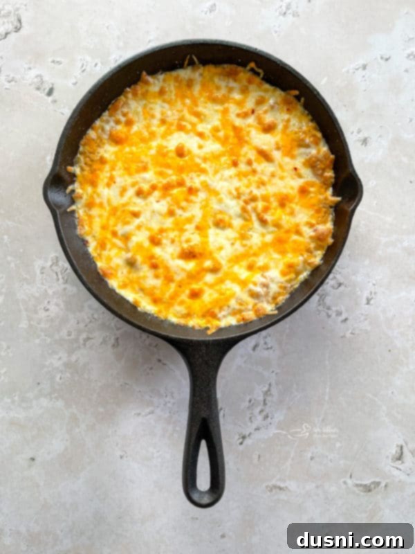 a hot skillet full of bean dip with melted cheese on top