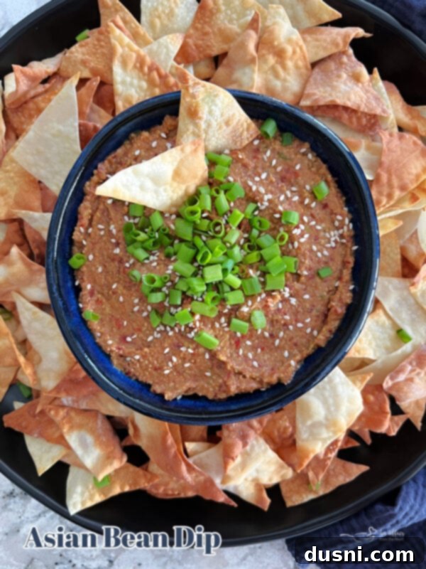 Asian Bean Dip in a blue bowl with dippers on a table