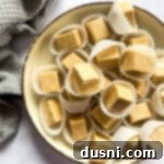 Decadent Peanut Butter Fudge 16 Peanut butter fudge stacked on a cream color dish.