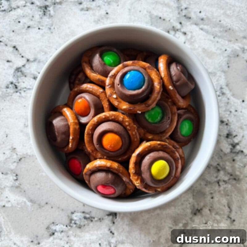 A festive holiday platter with various cookies and candies, including Rolo Pretzels