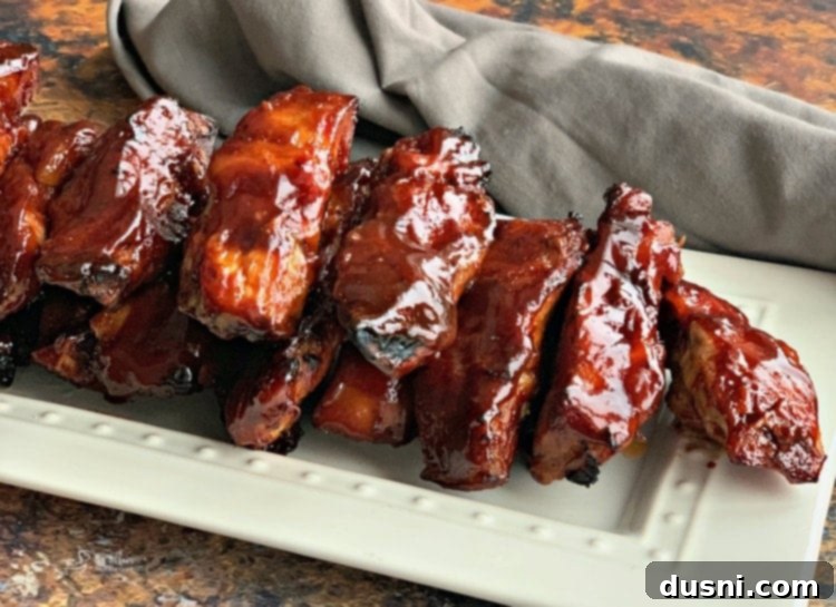 2022's Culinary Highlights: Our Top 10 Recipes 10 Close up of Slow Cooker Dr. Pepper BBQ Ribs on a white serving plate, garnished