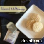 Overhead of cookies on a white plate with text "Almond Meltaways"