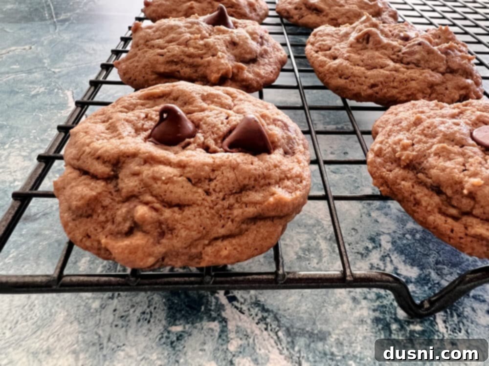 A large batch of Bailey's Chocolate Chip Cookies cooling on multiple wire racks.