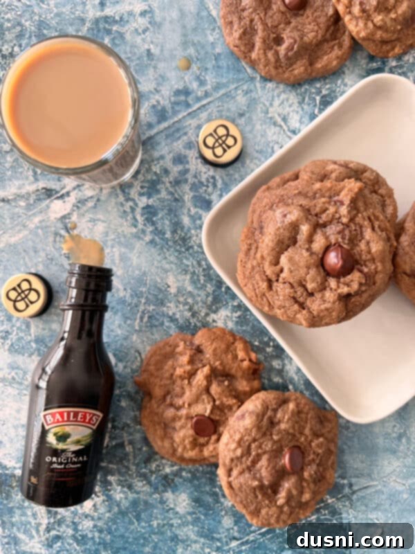 Two Bailey's Chocolate Chip Cookies on a plate, with a background of an Irish Cream bottle.