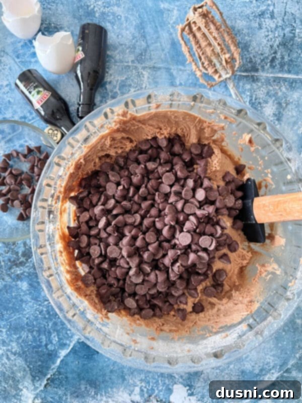 Folding chocolate chips into the prepared Bailey's cookie dough.