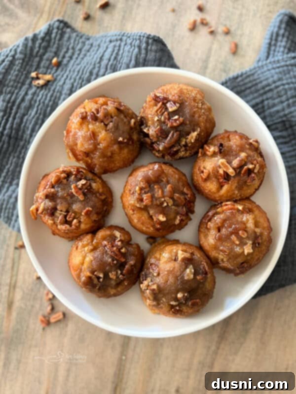 Banana Pecan Swirls 3 Plate of freshly baked banana pecan sticky rolls, with a few extra rolls scattered around and a whole banana in the background.