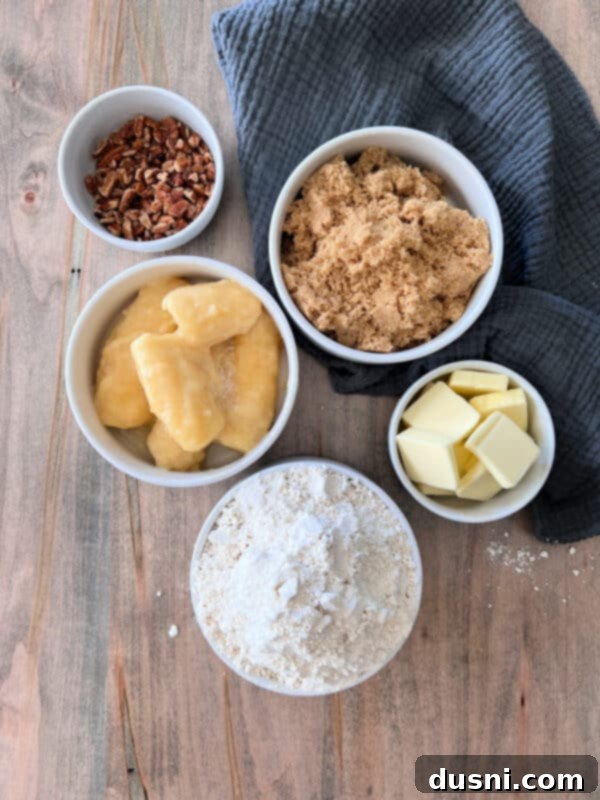 Banana Pecan Swirls 4 A close-up of a single banana pecan sticky roll on a white plate, garnished with a fresh banana slice and a sprinkle of chopped pecans.