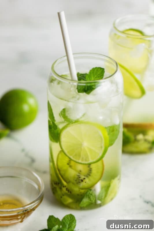 Vibrant Kiwi Mojito 3 Fresh ingredients for Kiwi Mojitos, including whole kiwifruit, limes, mint, and honey.