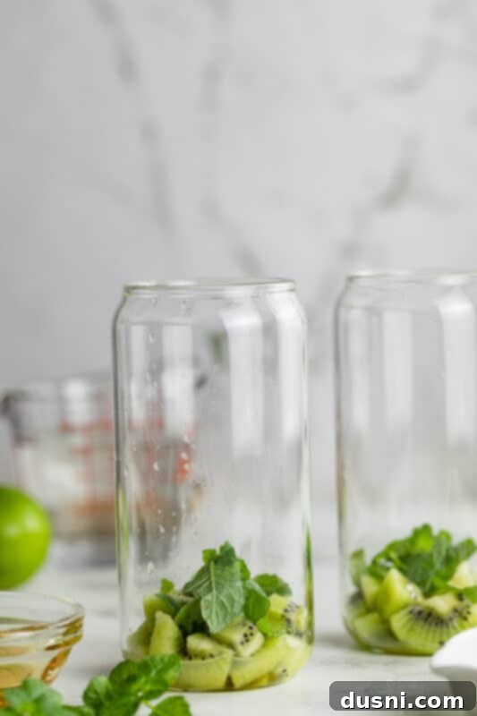 Vibrant Kiwi Mojito 5 Step two: Lime juice, mint leaves, and honey added to diced kiwi in a glass.