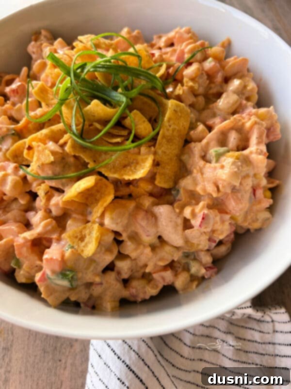 Loaded Frito Corn Salad 4 Overhead view of Frito Corn Salad in a large serving bowl, with Frito chips arranged around the edges.