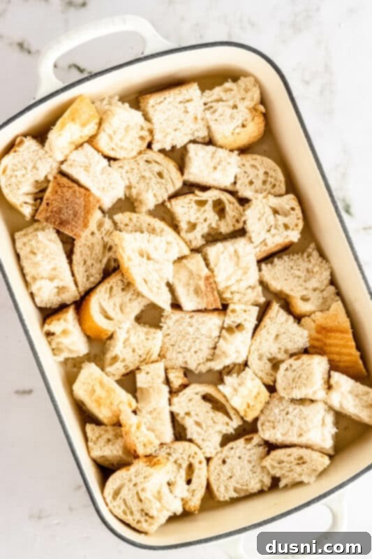 Step 1: Cubed French bread arranged in a baking dish.