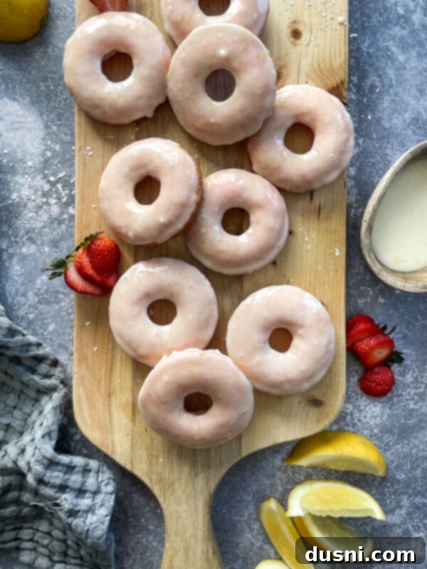 Sun-Kissed Strawberry Lemonade Donuts 10 A stack of three baked strawberry lemonade donuts on a white plate