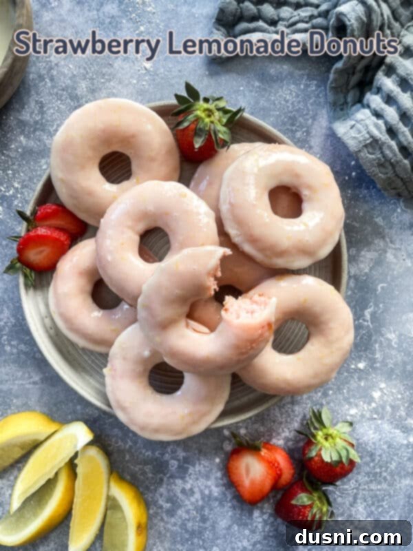 Sun-Kissed Strawberry Lemonade Donuts 12 A platter of baked strawberry lemonade donuts, garnished with fresh strawberries and lemon slices