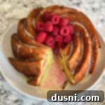 Sunshine Lemon Raspberry Bundt Cake 10 Overhead of lemon raspberry bundt cake on a white plate