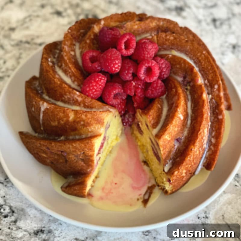 Sunshine Lemon Raspberry Bundt Cake 2 A beautiful slice of Lemon Raspberry Bundt Cake showing the moist interior and raspberries