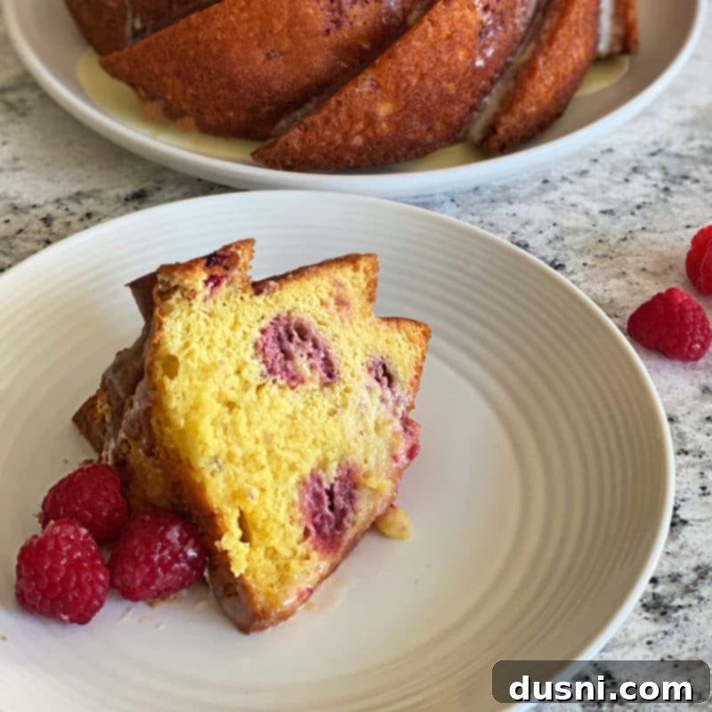 Sunshine Lemon Raspberry Bundt Cake 5 Glazed Lemon Raspberry Bundt Cake on a serving platter, ready to be cut
