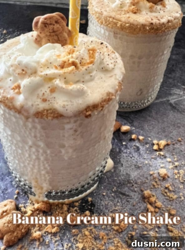 Banana Cream Dream Shake 13 Large hero shot of Banana Cream Pie Shake with a straw, whipped cream, and graham cracker topping