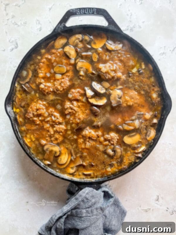 Classic Salisbury Steak with Savory Mushroom Gravy 12 Salisbury steak patties simmering in rich mushroom and onion gravy