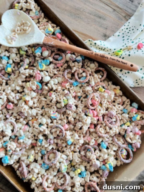 Pot of Gold Snack Blend 14 Spreading the coated snack mix onto a parchment-lined baking sheet.