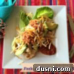 Overhead of dressed Taco on a white plate with text "Fork & Knife Chicken Tacos"