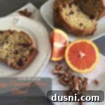 Orange Cranberry Pecan Loaf 2 Overhead of a slice of bread on a white plate with text "Orange Cranberry Pecan Bread"