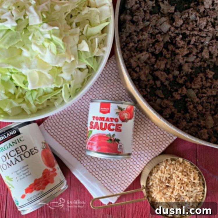 Ground beef and chopped onion browning in a large skillet, the initial step for unstuffed cabbage rolls.