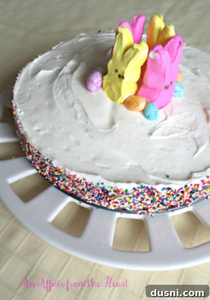 Dreamy Marshmallow Cloud Cheesecake 3 A slice of fluffy marshmallow cheesecake on a white plate, showcasing its light texture and sprinkles.