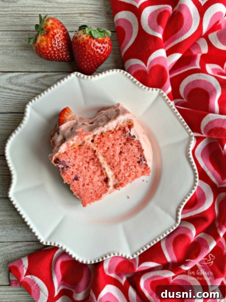 Velvet Strawberry Dream 5 A slice of Strawberry Cake revealing multiple layers and generous strawberry pieces within.