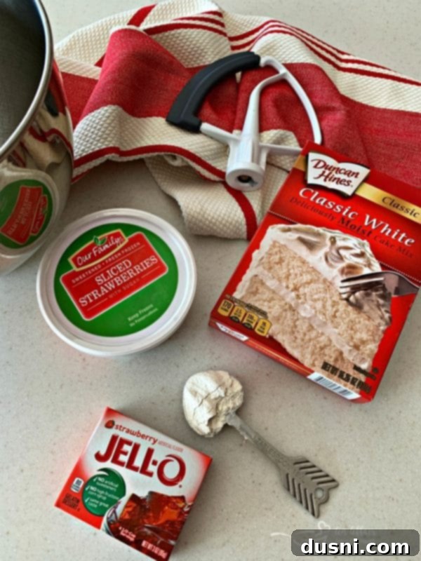 Velvet Strawberry Dream 6 Ingredients for Strawberry Cake laid out on a table, including cake mix, jell-o, and strawberries.