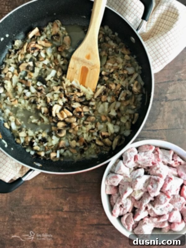 Tender Beef Tips in Rich Gravy 7 Mushrooms, onions, and garlic being sautéed in a pan, releasing their aromatic flavors.