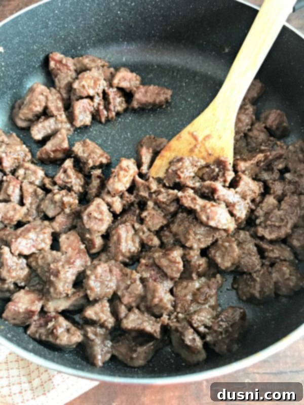 Tender Beef Tips in Rich Gravy 8 Beef tips coated in flour, salt, and pepper, browning in a hot skillet to develop a rich crust.