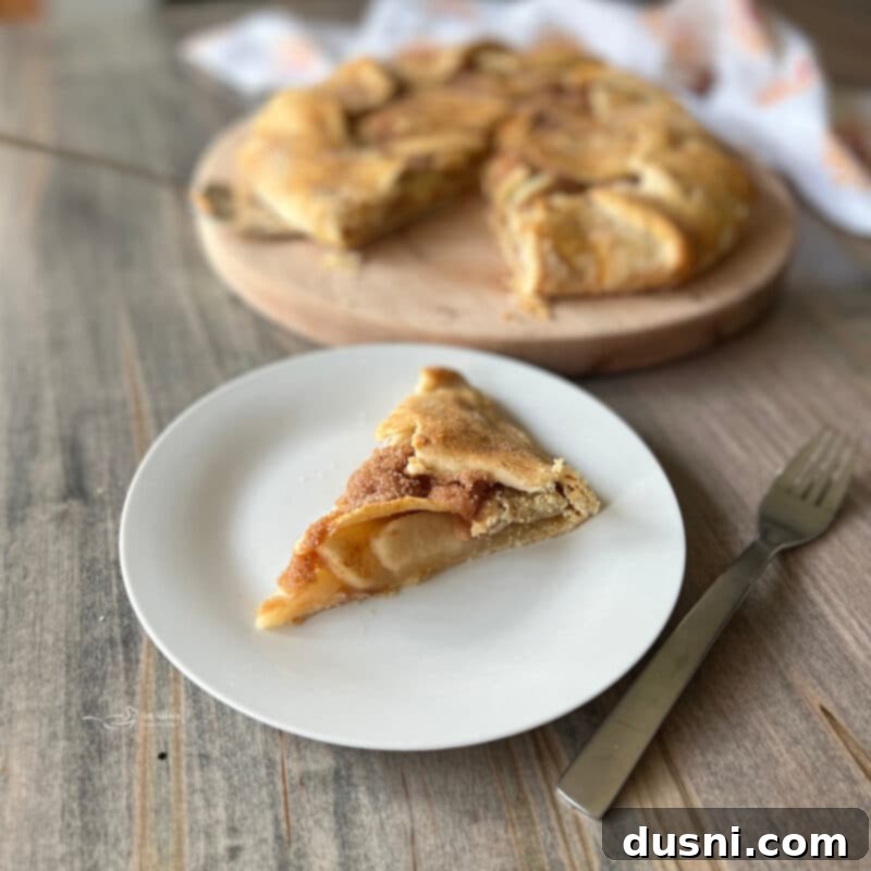 Close-up of a rustic apple crostata with a slice cut out