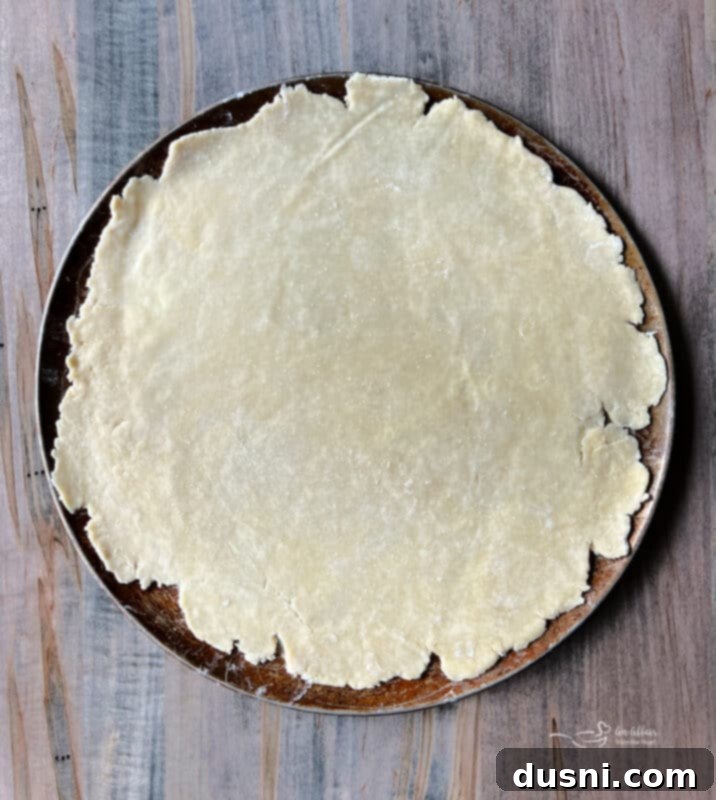 Dough rolled out on a baking sheet, ready for filling
