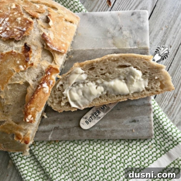 Sliced No Knead Crusty Dutch Oven Bread, served warm with butter.
