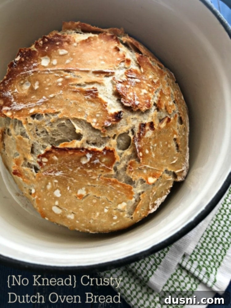 A beautifully golden-brown, rustic No Knead Crusty Dutch Oven Bread on a cooling rack.