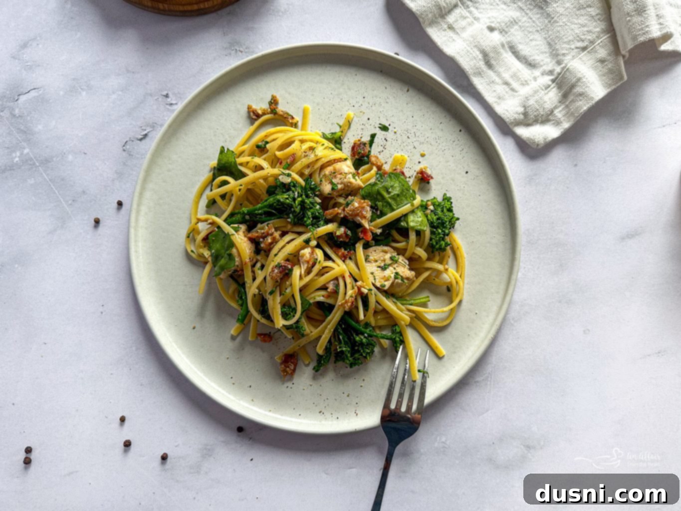 A generous serving of creamy chicken carbonara in a white bowl, garnished with fresh parsley.