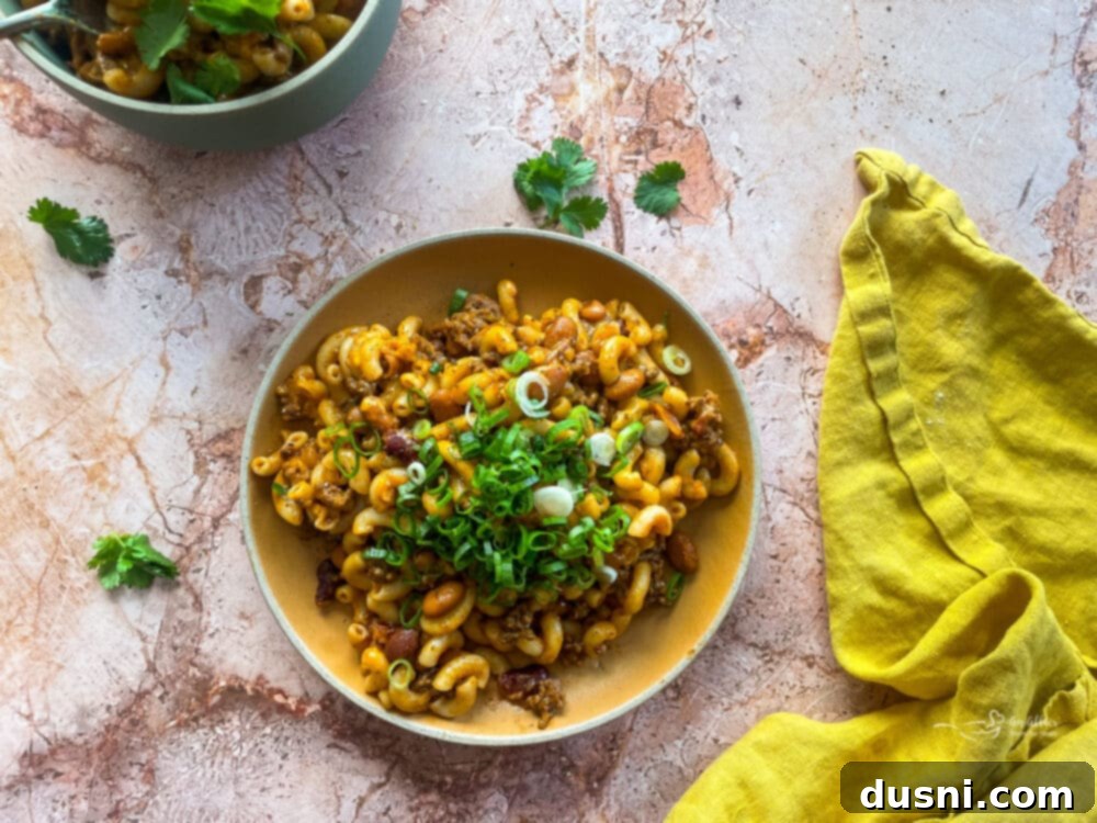 Hearty One-Pan Chili Mac 12 A bowl of garnished Chili Mac Skillet, topped with fresh green onions and cilantro.