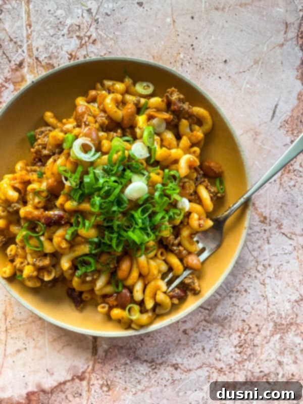Hearty One-Pan Chili Mac 16 Serving of Chili Mac Skillet in a bowl with a spoon.