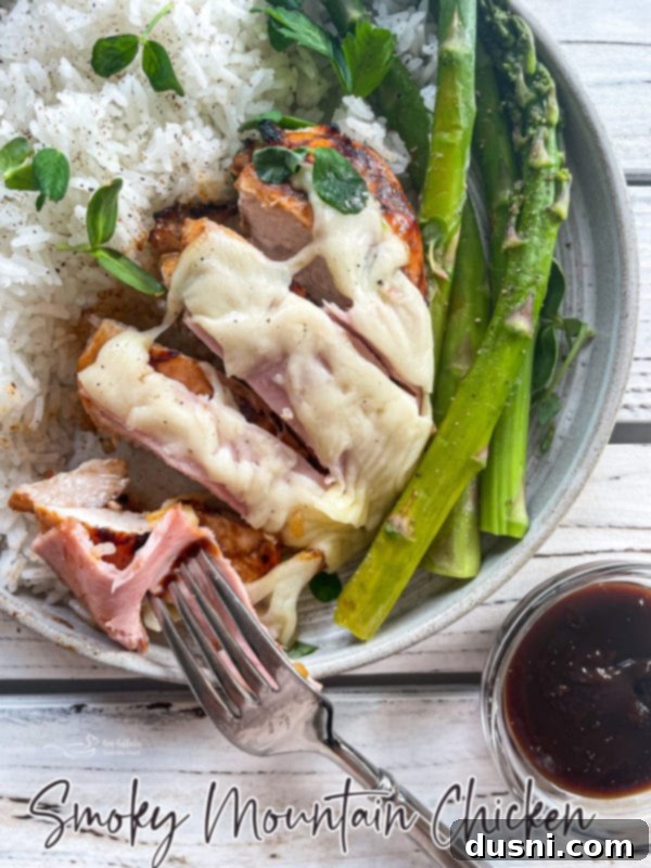 A final presentation of Smoky Mountain Chicken, garnished with fresh herbs and served with a side of asparagus