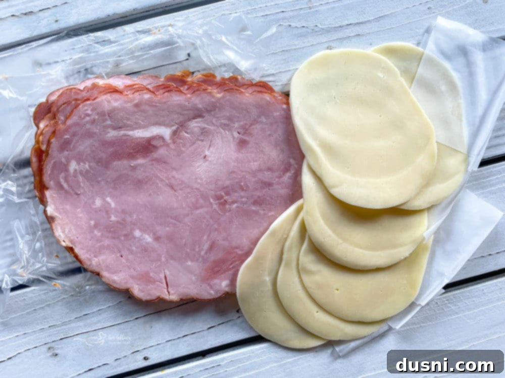 Slices of thick-cut ham and provolone cheese, essential ingredients for Smoky Mountain Chicken
