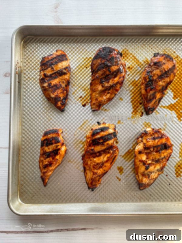Marinated chicken breasts arranged on a baking sheet, ready for grilling or baking