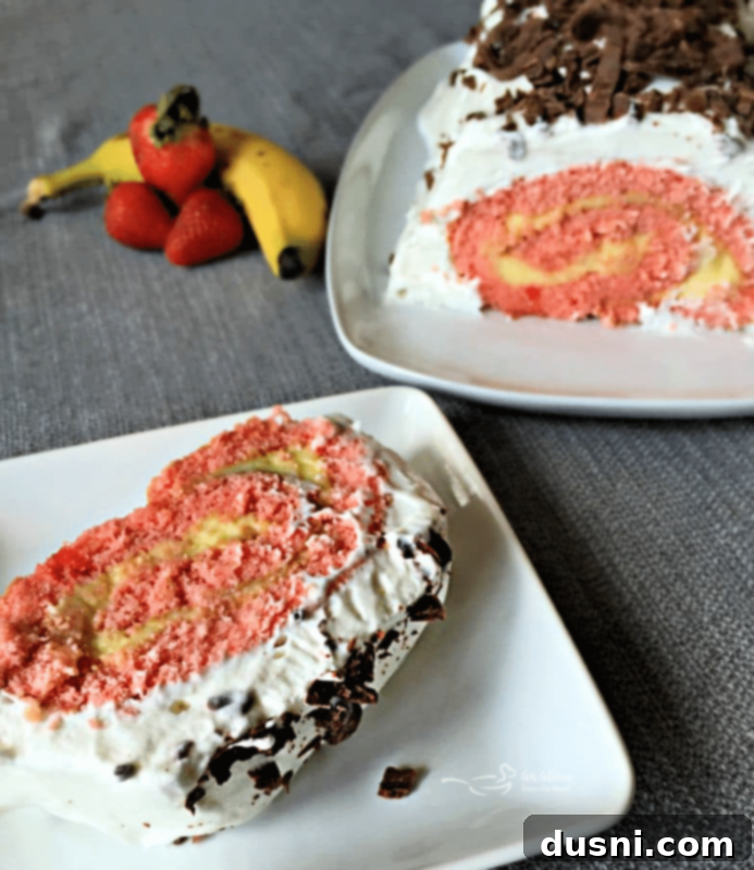 Ultimate Banana Split Jelly Roll 2 Banana Split Jelly Roll Cake, sliced, showing strawberry cake with banana pudding swirl, whipped cream, and chocolate shavings