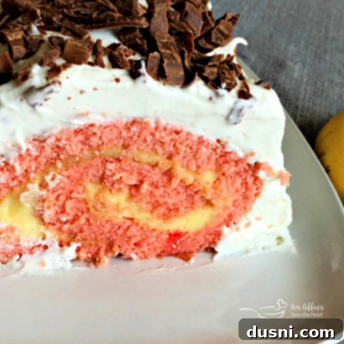 Ultimate Banana Split Jelly Roll 4 Close-up of a slice of Banana Split Jelly Roll Cake showing the internal swirl and texture