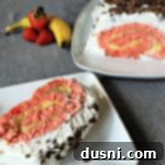 Ultimate Banana Split Jelly Roll 9 Slice of cake on a white plate and the rest of the roll on a white platter